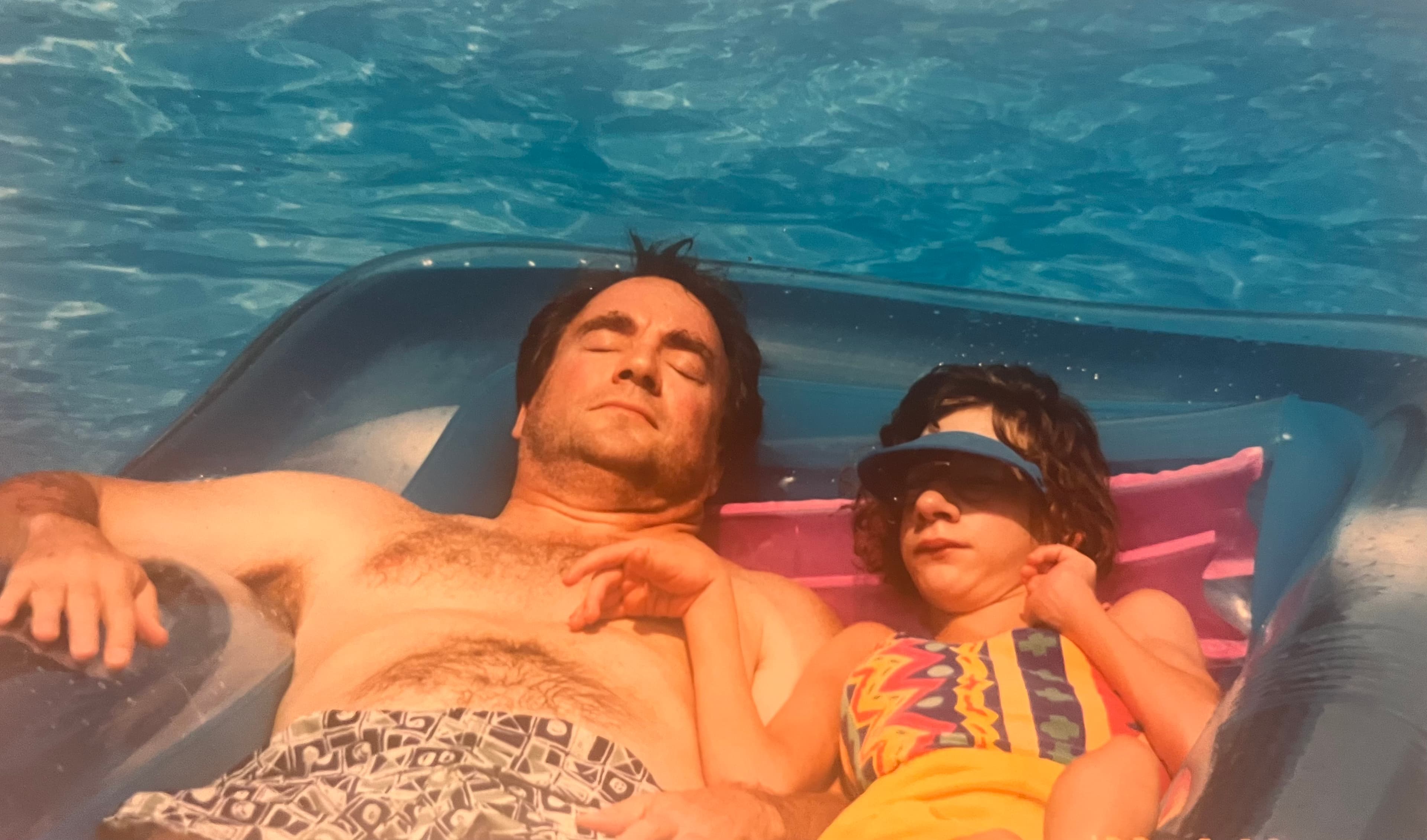 Elizabeth as a child with her father floating in a pool