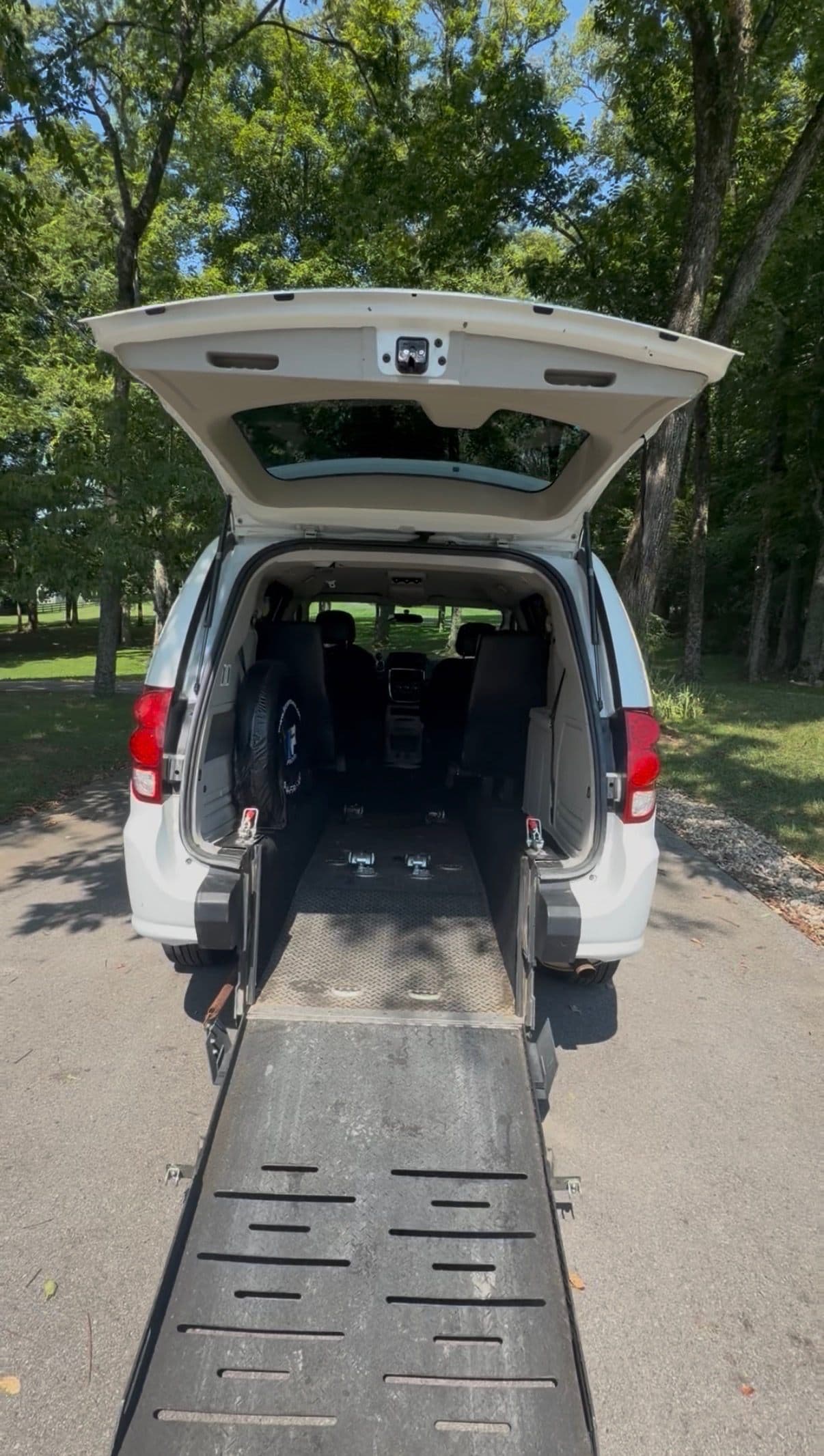 View up the rear-entry wheelchair ramp into the van's open interior, showing the wheelchair area and tie-downs
